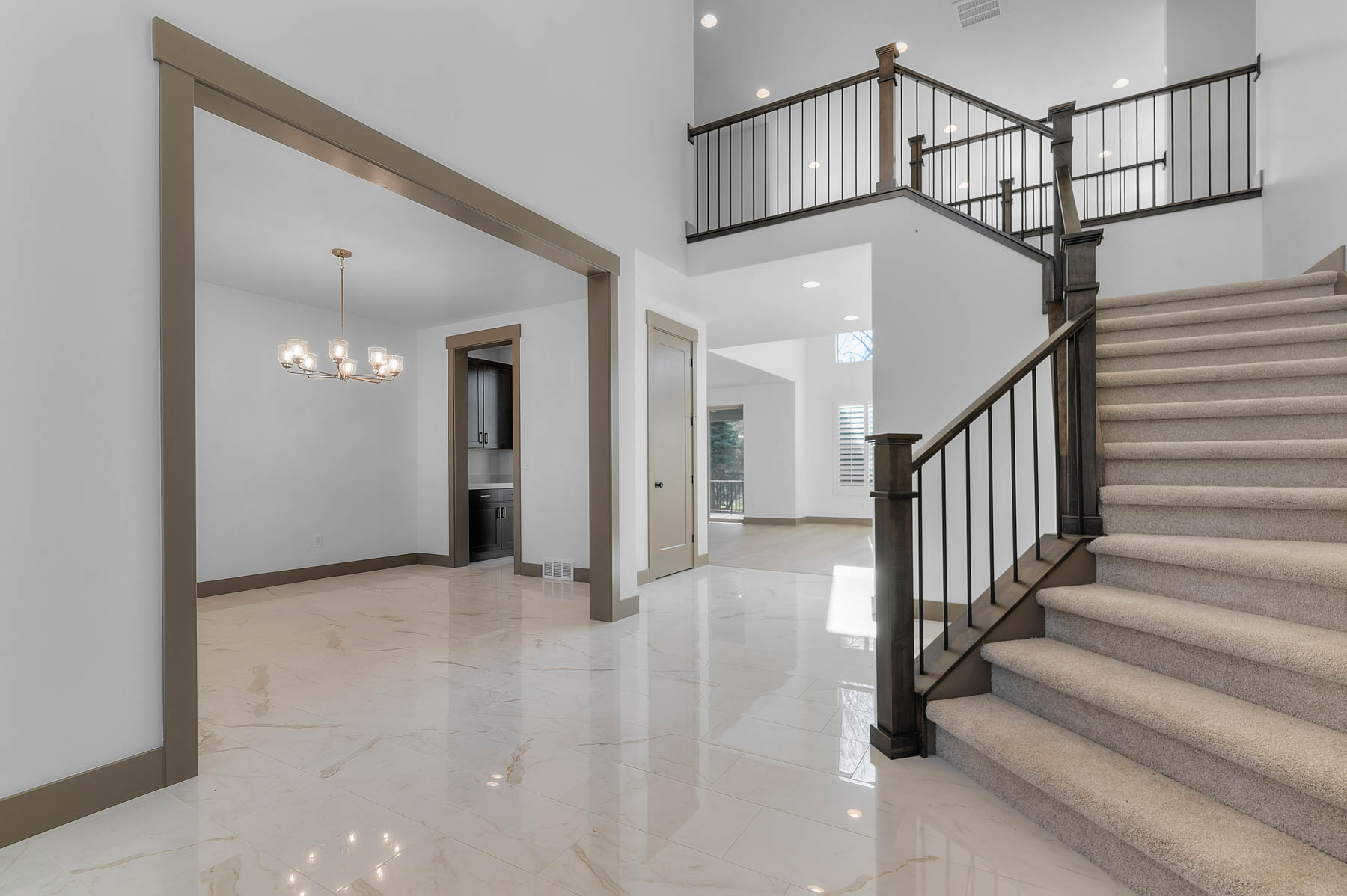 Staircase featuring suspended lighting, marble tiled flooring, and a high ceiling