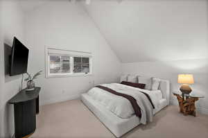 Carpeted bedroom featuring vaulted ceiling and baseboards