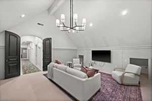 Living area featuring carpet flooring, a decorative wall, recessed lighting, arched walkways, and a chandelier