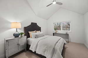 Carpeted bedroom with ceiling fan and lofted ceiling