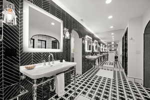Master Bathroom with recessed lighting, two sinks, and tile walls