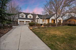 Modern farmhouse featuring concrete driveway, a chimney, and an attached garage
