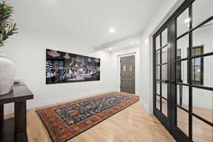 Entrance foyer with light wood-style flooring, recessed lighting, and french doors
