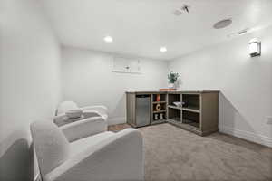 Sitting room with light carpet and recessed lighting