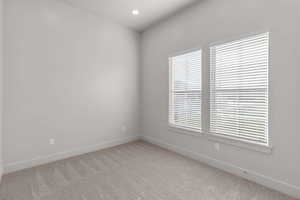 Spare room featuring light colored carpet and recessed lighting