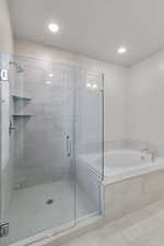 Bathroom featuring a garden tub, a stall shower, tile patterned floors, and recessed lighting