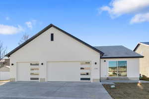 View of front of house featuring driveway and roof with shingles