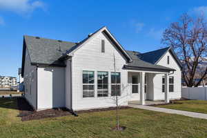 View of front facade with roof with shingles and a porch