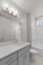 Full bath featuring vanity, bathtub / shower combination, and light tile patterned flooring