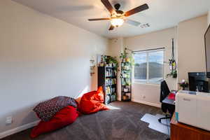Office featuring dark carpet and a ceiling fan