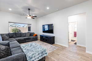 Living room featuring light wood-style floors, ceiling fan, and recessed lighting