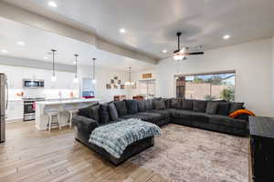 Living room featuring light wood-style flooring, ceiling fan, and recessed lighting