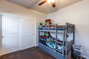 Bedroom featuring dark carpet, a closet, and ceiling fan