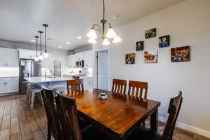 Dining space featuring dark wood-type flooring, a chandelier, and recessed lighting
