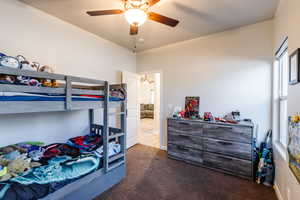 Carpeted bedroom with a ceiling fan