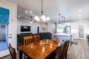 Dining room featuring a chandelier, wood tiled floors, recessed lighting, and ceiling fan