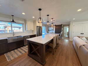 Kitchen featuring a barn door, stainless steel appliances, open floor plan, decorative backsplash, and a center island