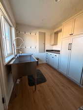 Washroom / Laundry room with deep sink & storage