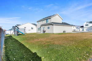 Back of house with a playground, a fenced backyard, stucco siding, and a patio