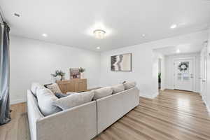 Living area featuring light wood-style floors and recessed lighting
