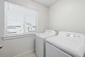 Washroom with baseboards and independent washer and dryer