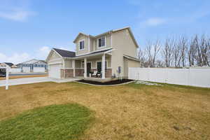 View of front of house featuring covered porch, board and batten siding, brick siding, concrete driveway, and a gate
