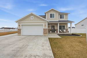 Craftsman house featuring covered porch, brick siding, driveway, board and batten siding, and an attached garage