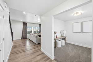 Corridor with light wood-style floors and recessed lighting