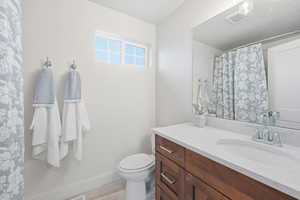 Full bath with vanity, curtained shower, and light wood-style floors