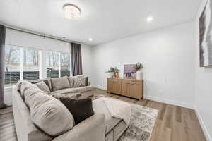 Living area featuring light wood-type flooring and recessed lighting