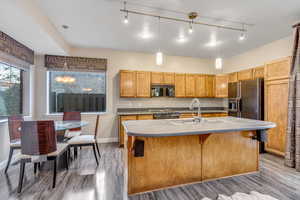 Kitchen with rail lighting, pendant lighting, black appliances, and dark wood-style flooring