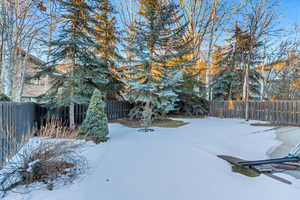 Yard layered in snow with a fenced backyard