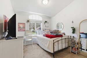 Bedroom with carpet flooring and lofted ceiling