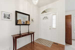 Entrance foyer with wood finished floors and vaulted ceiling