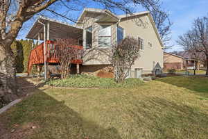 Back of house featuring a deck and a yard