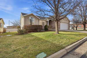 Single story home featuring concrete driveway, stucco siding, brick siding, and a garage