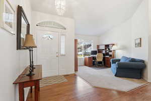 Entryway with light wood-style floors and vaulted ceiling