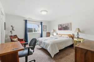 Carpeted bedroom featuring a desk