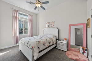 Bedroom with a ceiling fan and dark carpet