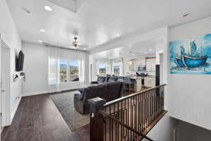 Living room featuring dark wood finished floors, a textured ceiling, and recessed lighting