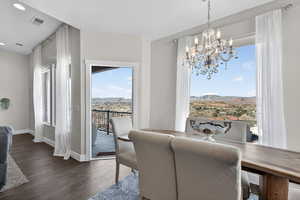 Dining space featuring a chandelier, dark wood finished floors, and a mountain view