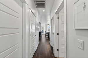 Corridor featuring dark wood-style flooring and recessed lighting