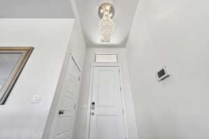 Doorway with a chandelier and a textured ceiling