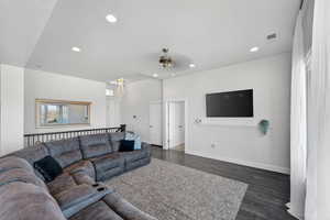Living area featuring dark wood finished floors, ceiling fan, and recessed lighting