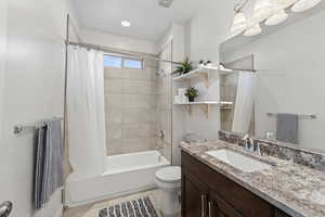 Full bathroom with shower / bath combo with shower curtain, vanity, and light tile patterned floors
