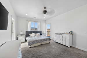 Carpeted bedroom featuring ceiling fan and recessed lighting