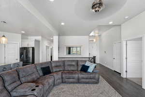 Living area with dark wood-type flooring, a textured ceiling, and recessed lighting