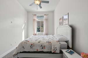 Carpeted bedroom featuring a ceiling fan and baseboards