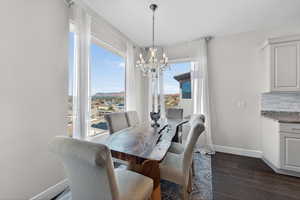 Dining space featuring a chandelier, dark wood-style floors, and a mountain view