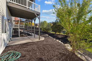 View of yard featuring stairs, a patio, and a wooden deck